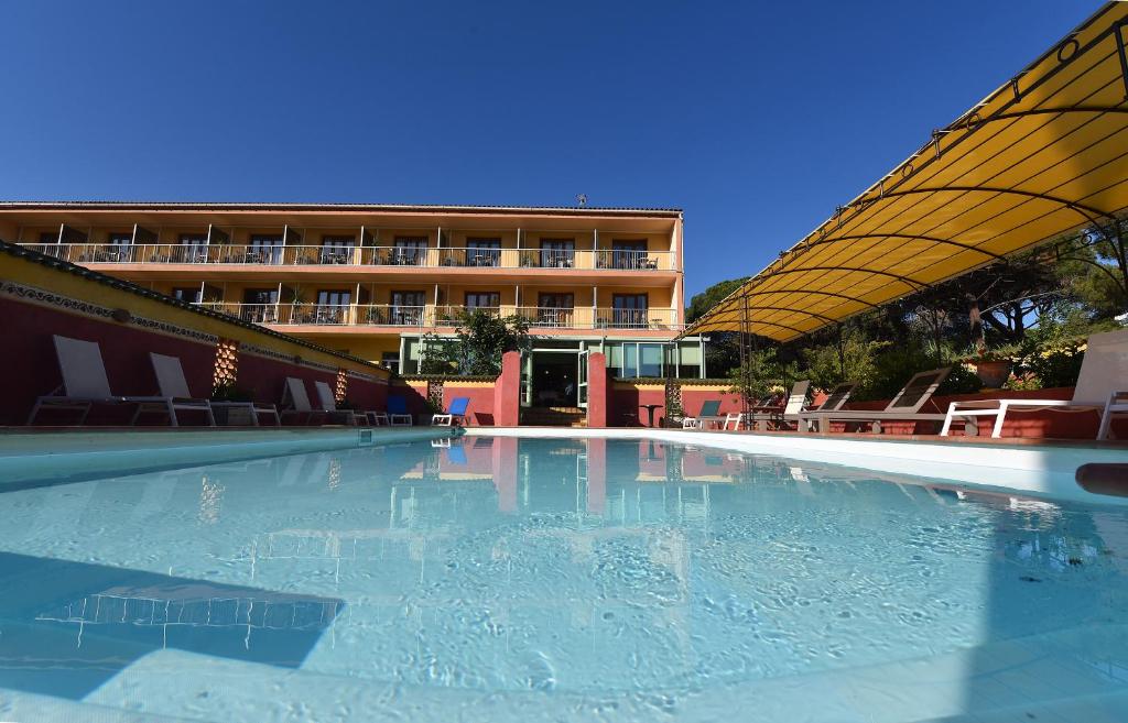 an empty swimming pool in front of a building at Hotel Cyrnea in Calvi