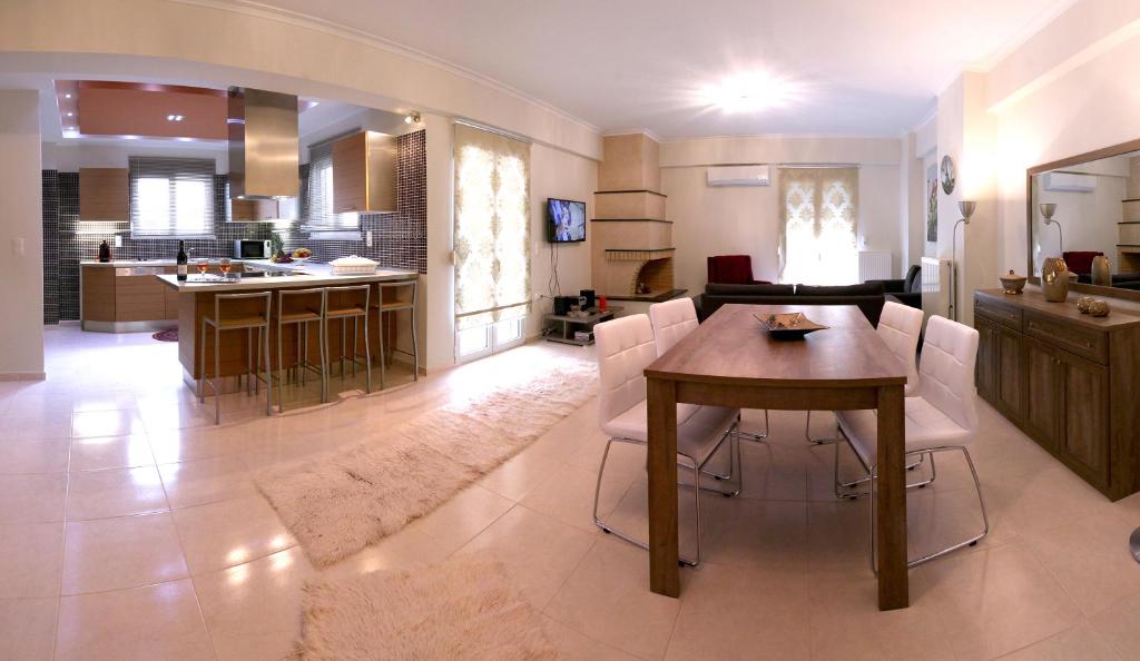 レティムノ・タウンにあるElena & Pelagia Luxury Apartmentのキッチン、リビングルーム(テーブル、椅子付)