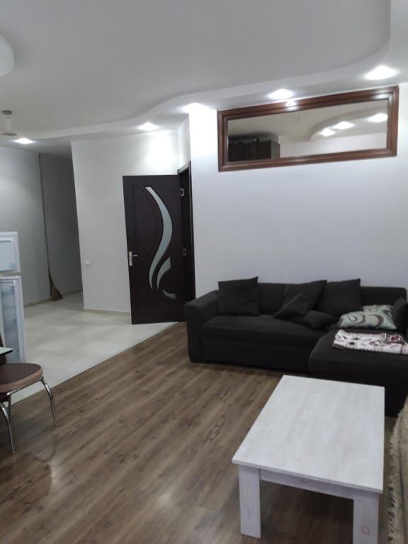 un soggiorno con divano nero e tavolo di Mari Apartment a Batumi