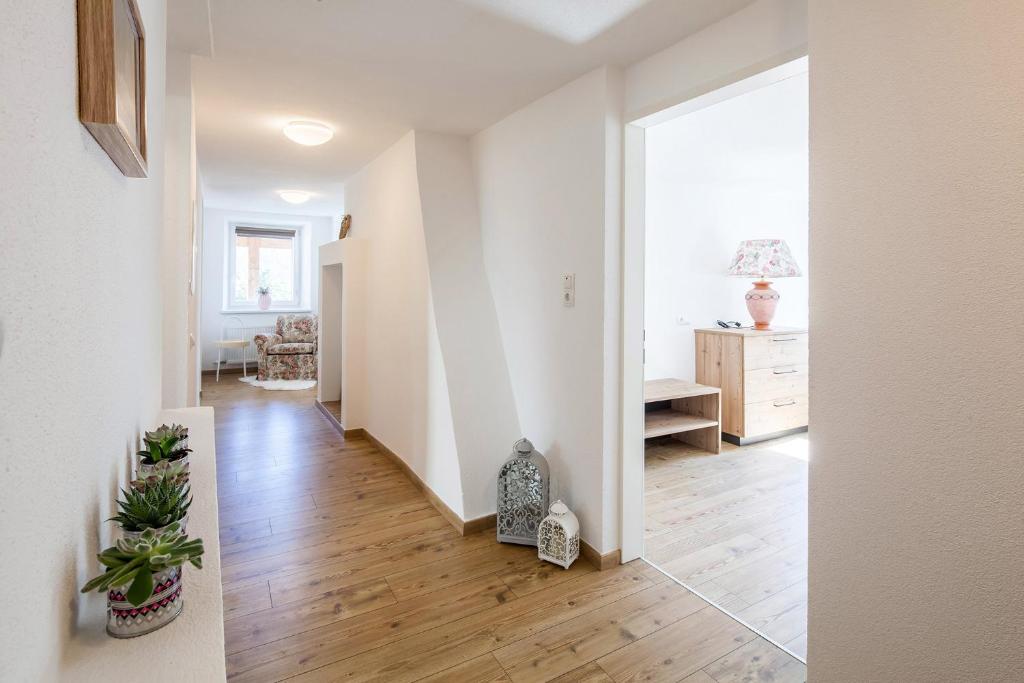 an empty living room with white walls and wood floors at Ferienwohnung bei Cooldog in Imst