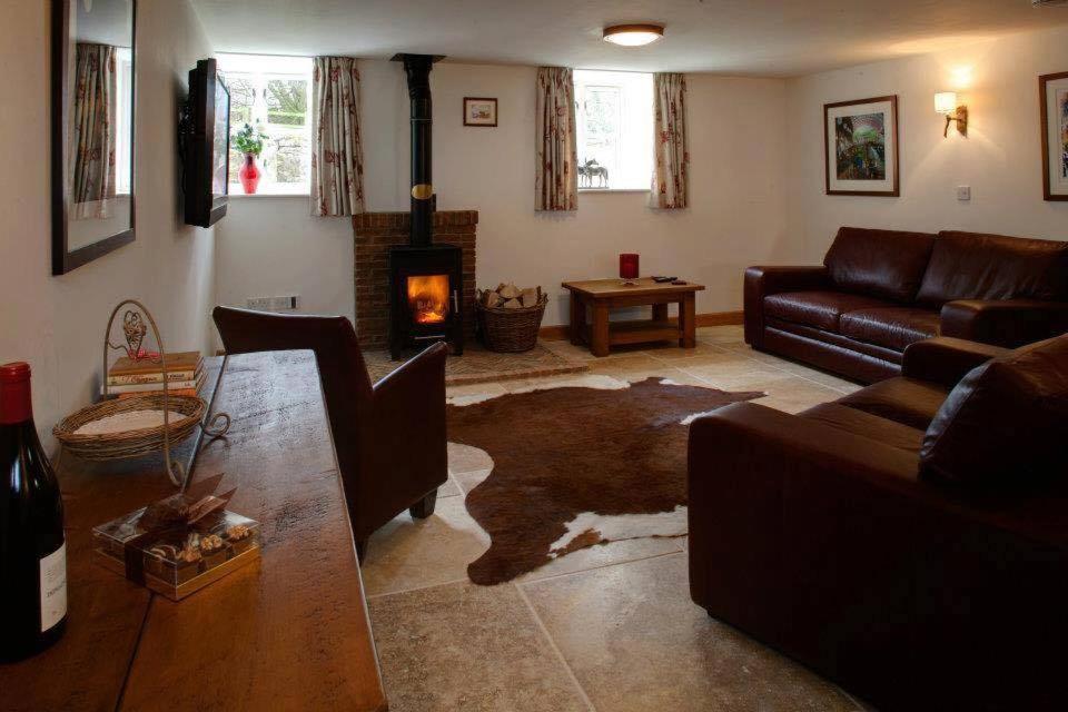 a living room with a couch and a fireplace at Squeak Cottage in Harrogate