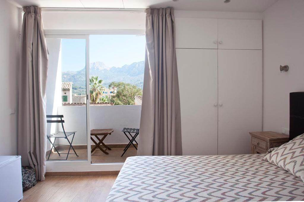 a bedroom with a bed and a view of a balcony at Hotel la Vila in Sóller