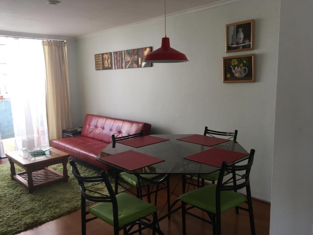 mesa de comedor con sillas y sofá rojo en La Dehesa House en Santiago