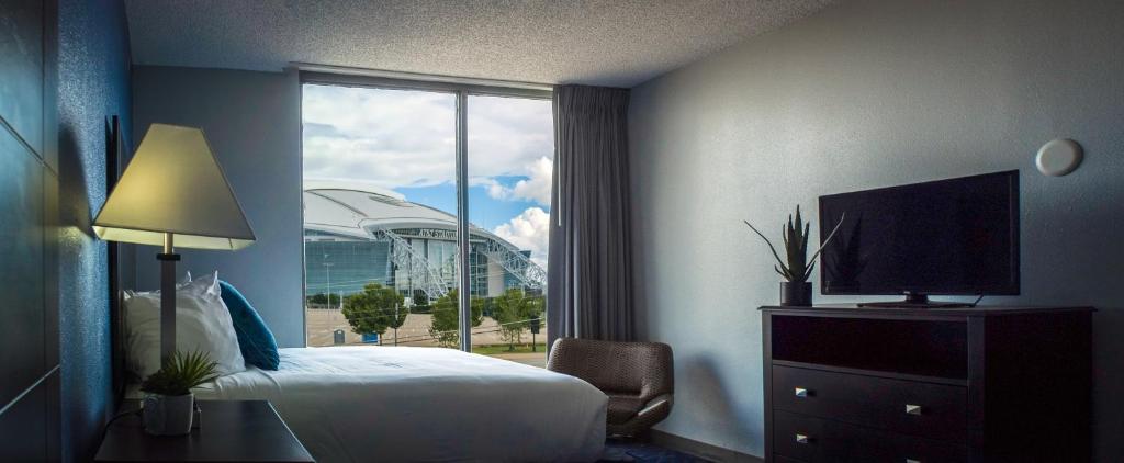 um quarto de hotel com uma cama e uma grande janela em Motel 6 Arlington TX Entertainment District em Arlington