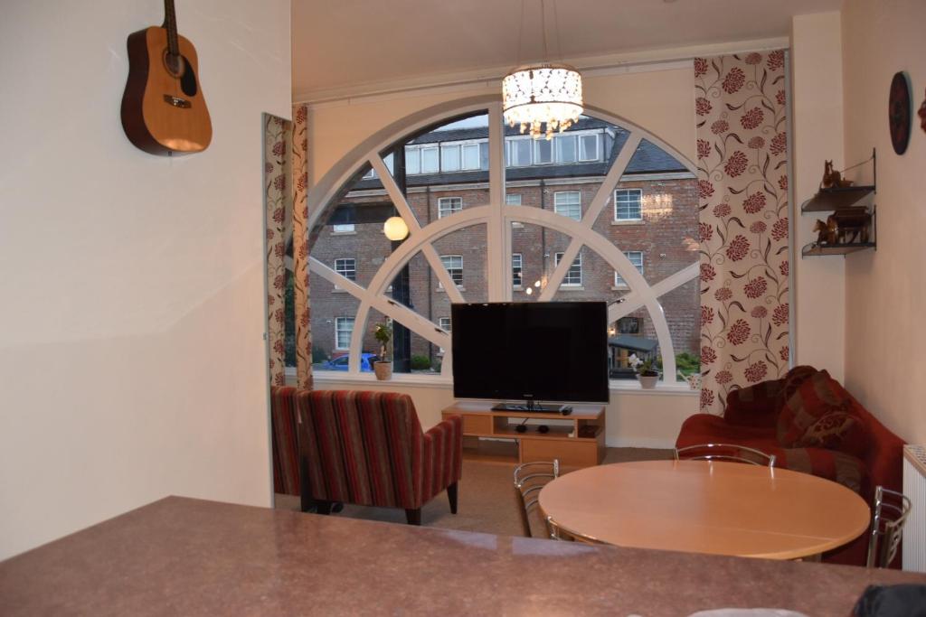 a living room with a large window and a television at Stunning 2 bedroom apartment in Glasgow