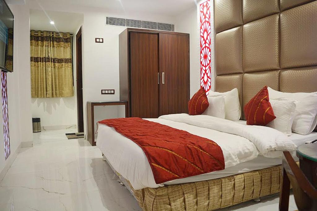 1 dormitorio con 1 cama grande con manta roja en Hotel Sun International, en Nueva Delhi
