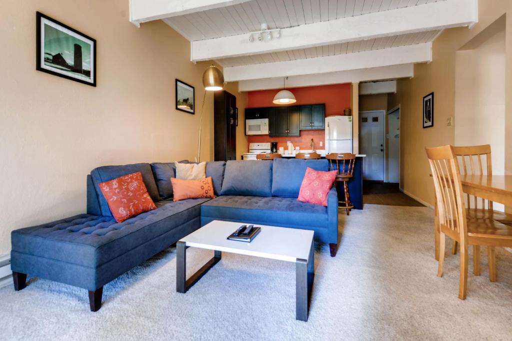 a living room with a blue couch and a table at One-Bedroom Sundowner Condo T4 in Breckenridge