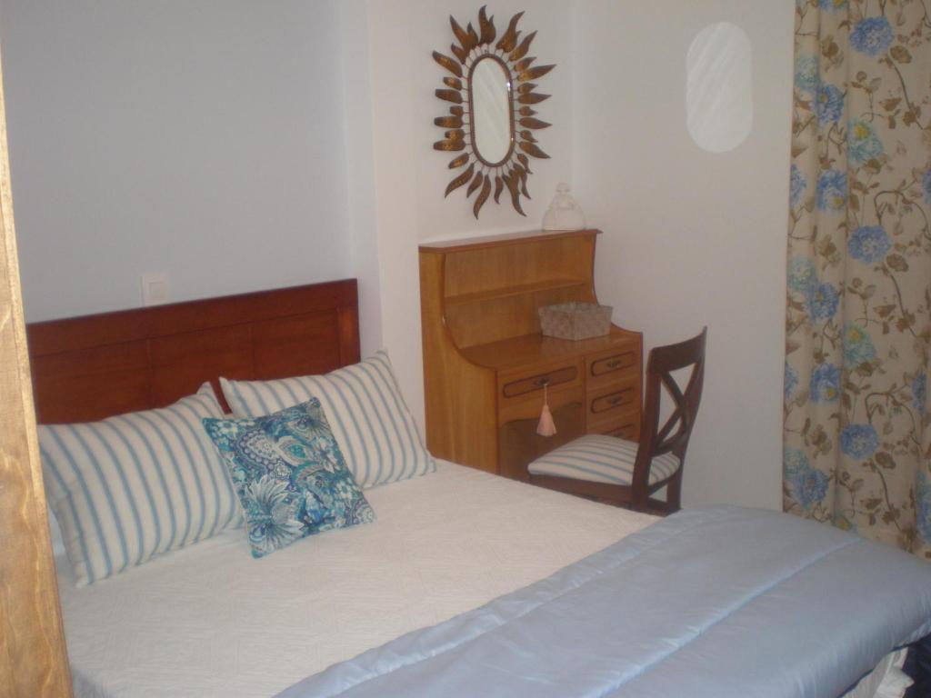 Pedro BernardoにあるApartamentos Albahacaのベッドルーム1室(ベッド1台、鏡付きデスク付)