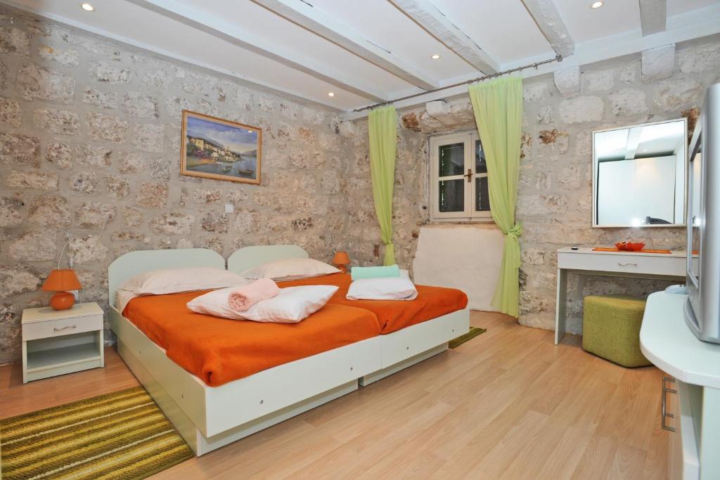 een slaapkamer met een bed met 2 kussens erop bij Studio Čikato in Dubrovnik