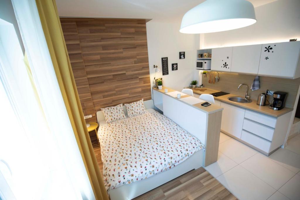 a small bedroom with a bed and a kitchen at Classy Scala Studio in Bucharest