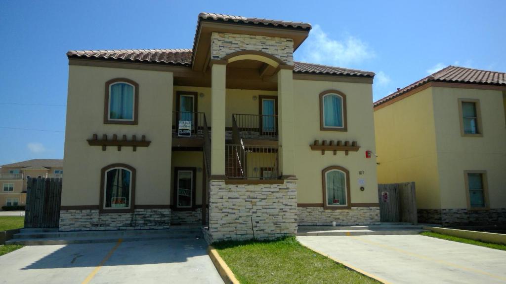 uma grande casa amarela com telhado de azulejo em 107 Pike on Oceanside em South Padre Island