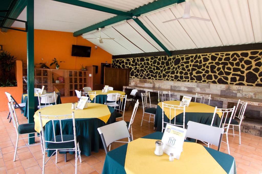 une salle à manger avec des tables et des chaises jaune et bleu dans l'établissement Hotel & Motel Hacienda Jiutepec, à Jiutepec