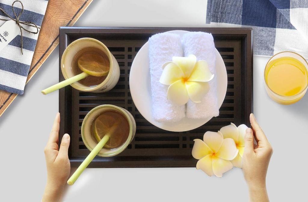 A tray-style food presentation pairs drinks with a flower-topped towel arrangement.