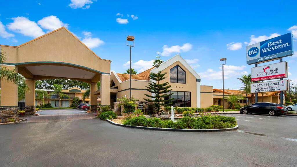 a best western hotel with a parking lot at Best Western Orlando West in Orlando