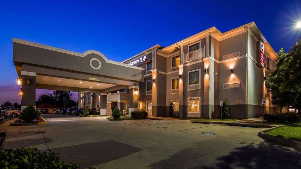 un gran edificio con un estacionamiento delante de él en Best Western Plus Chalmette Hotel en Chalmette