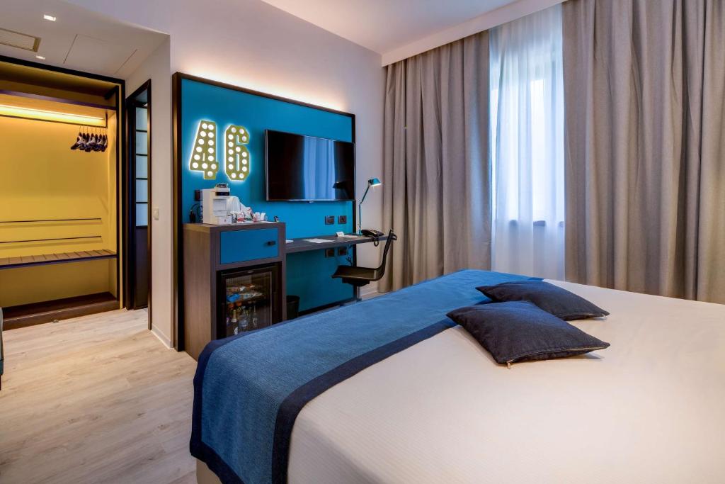 een slaapkamer met een groot bed en een televisie bij Best Western Hotel Cristallo in Rovigo