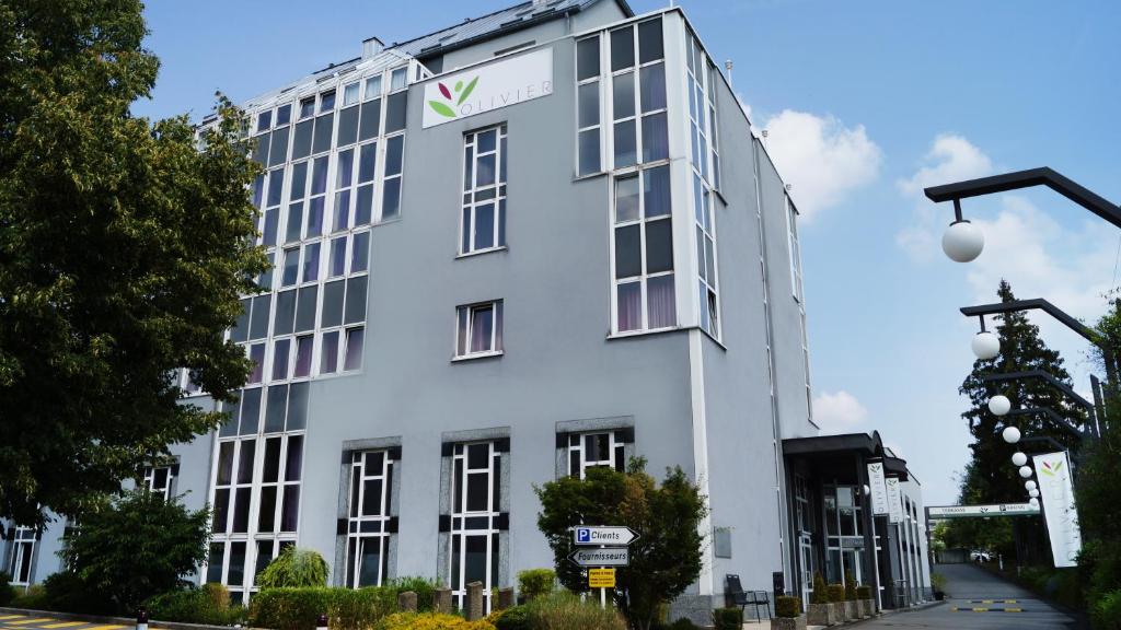 a white building with a sign on the side of it at Hotel Olivier in Luxembourg