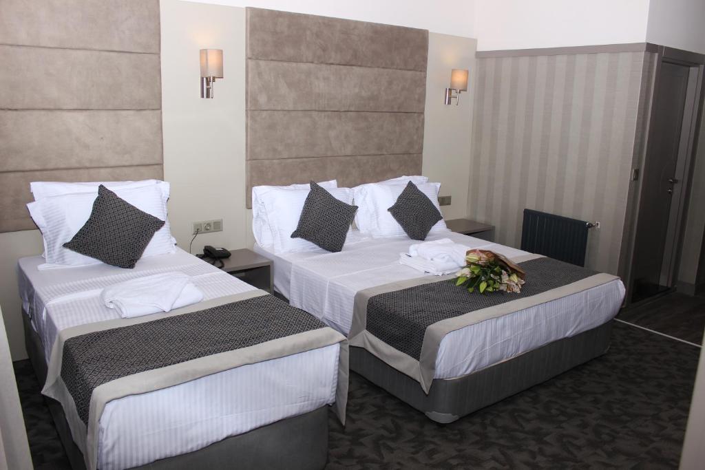 Dos camas en una habitación de hotel con flores. en Anka Premium Hotel en Estambul