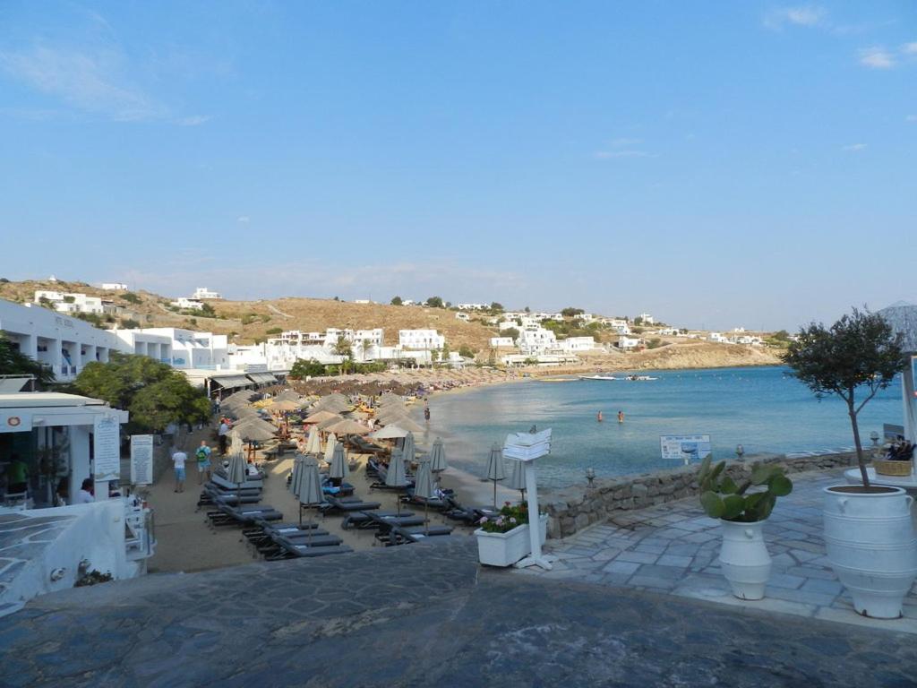 a view of a beach with chairs and the ocean at Studios Flora Manos in Platis Gialos