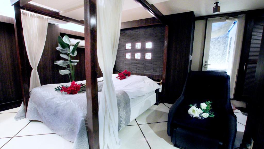 a bedroom with two beds and a mirror and flowers at agehA - Adult Only- in Fukuyama