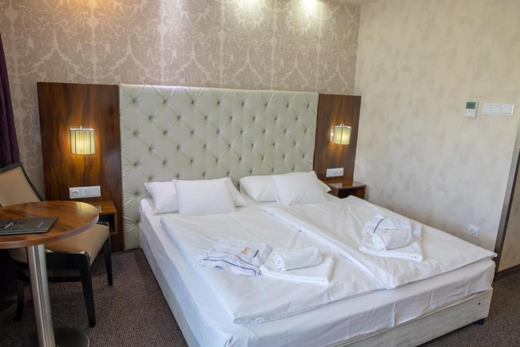 Postel nebo postele na pokoji v ubytování Bástya Konferencia és Wellness Hotel