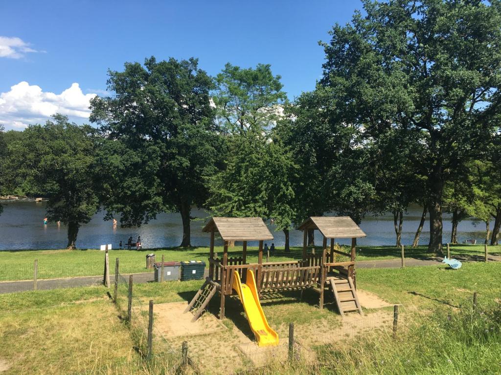 a park with a playground with a slide at Camping de la Bageasse in Brioude