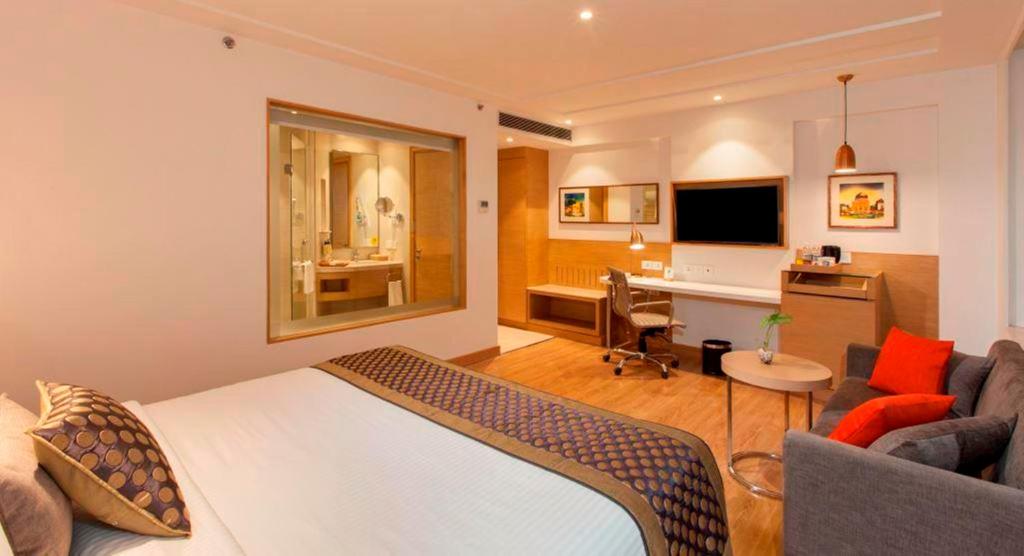Cette chambre comprend un lit et un bureau avec un ordinateur. dans l'établissement Lemon Tree Hotel Lucknow, à Lucknow