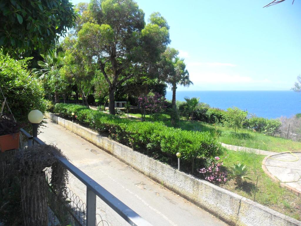 una pasarela junto a un jardín con el océano en el fondo en Casa Giusy, en Capo Vaticano