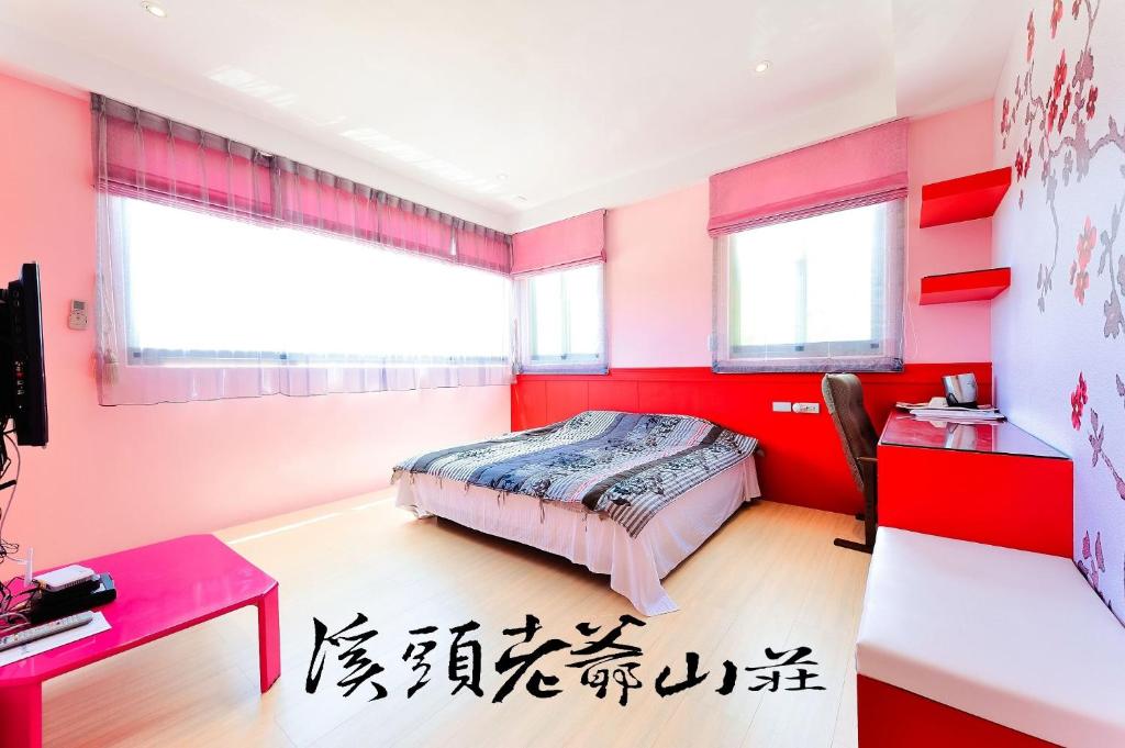 a bedroom with red walls and a bed and a desk at 溪頭老爺山莊Xitou Royal Villa in Lugu