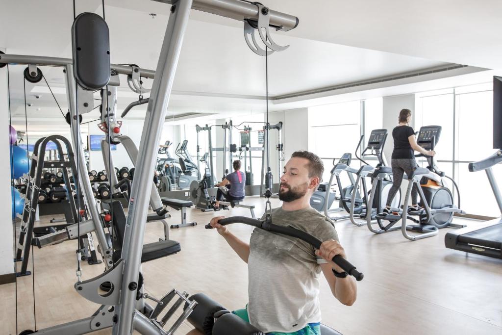 a man exercising in a gym with a machine at Royal M Hotel Fujairah by Gewan in Fujairah