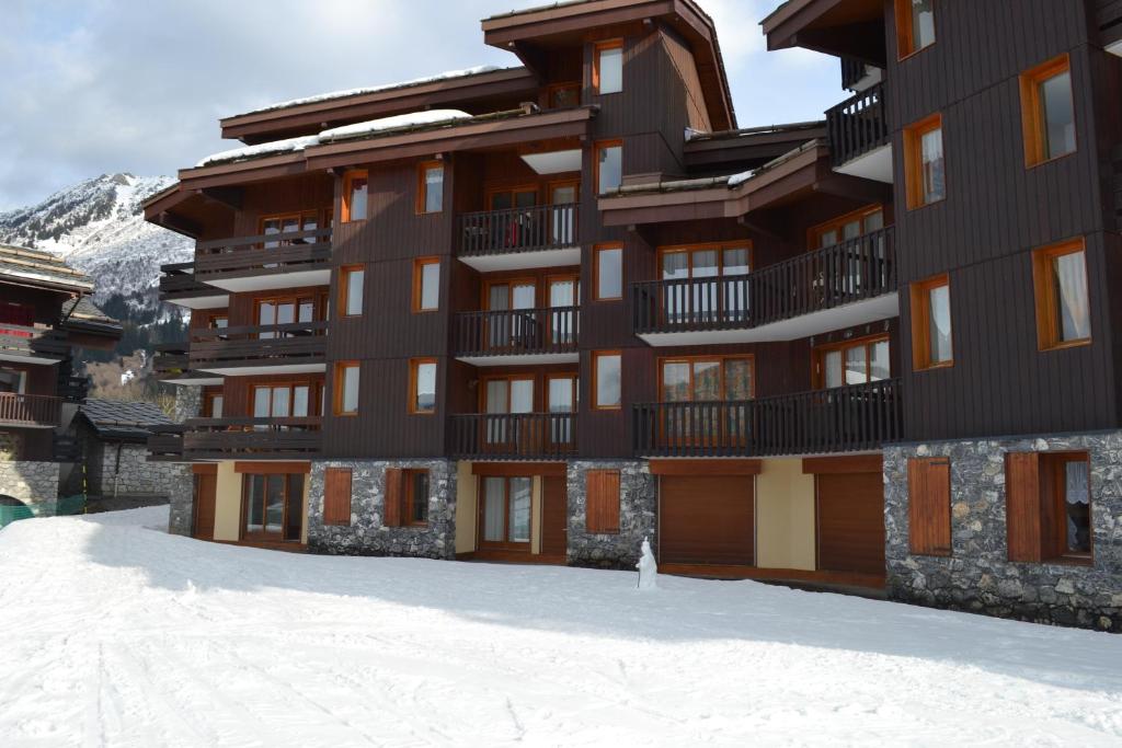 a large building with snow in front of it at Valmorel Studio Skis aux pieds in Valmorel