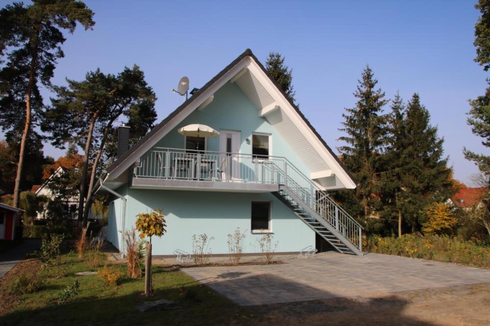 uma casa com uma varanda ao lado em K 102 EG - moderne Barrierefreie Ferienwohnung mit wunderschönen Garten in Röbel an der Müritz em Marienfelde