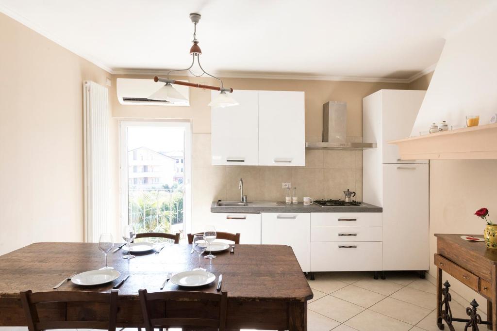 a kitchen with a wooden table and a dining room at Al Tuscany Flat in Lucca