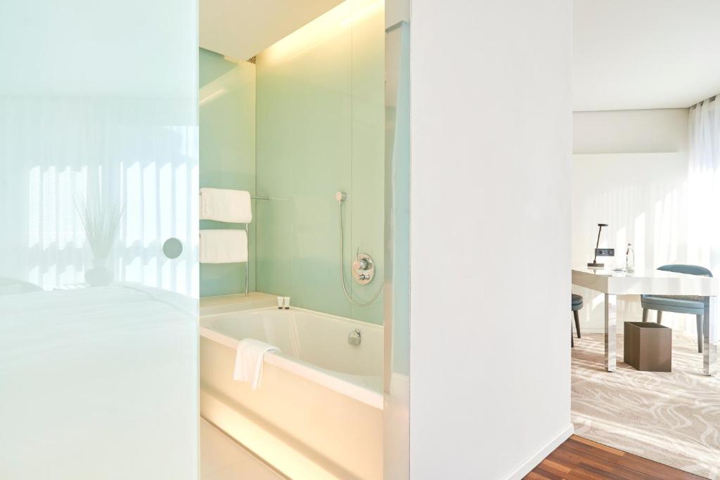 a bathroom with a bath tub and a table at SIDE, Hamburg, a Member of Design Hotels in Hamburg