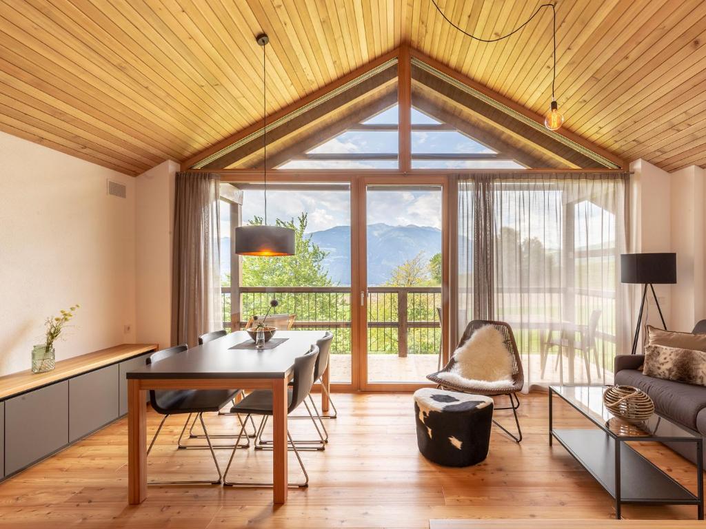 a living room with a table and a large window at Kronplatz CHALET WALCHHORN Brunico Dolomites in Brunico