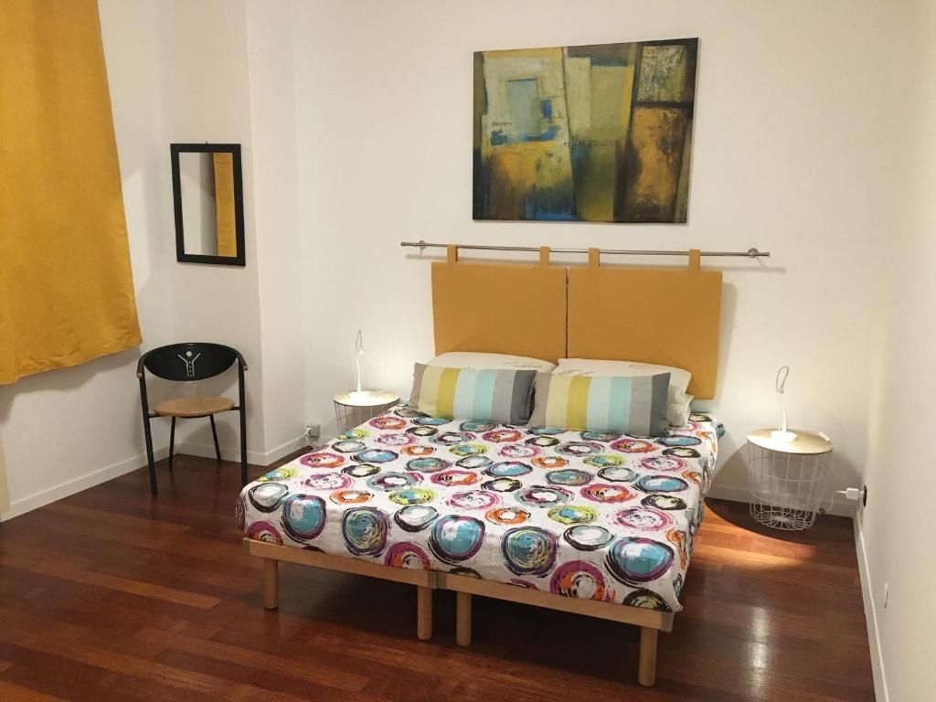ein Schlafzimmer mit einem Bett und zwei Tischen mit Lampen in der Unterkunft Victory in Gorizia