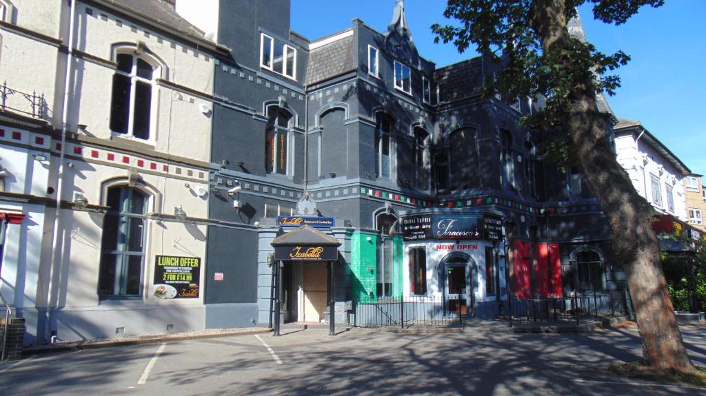 an old building on a city street with a tree at The Dorchester Serviced Apartments in Hull