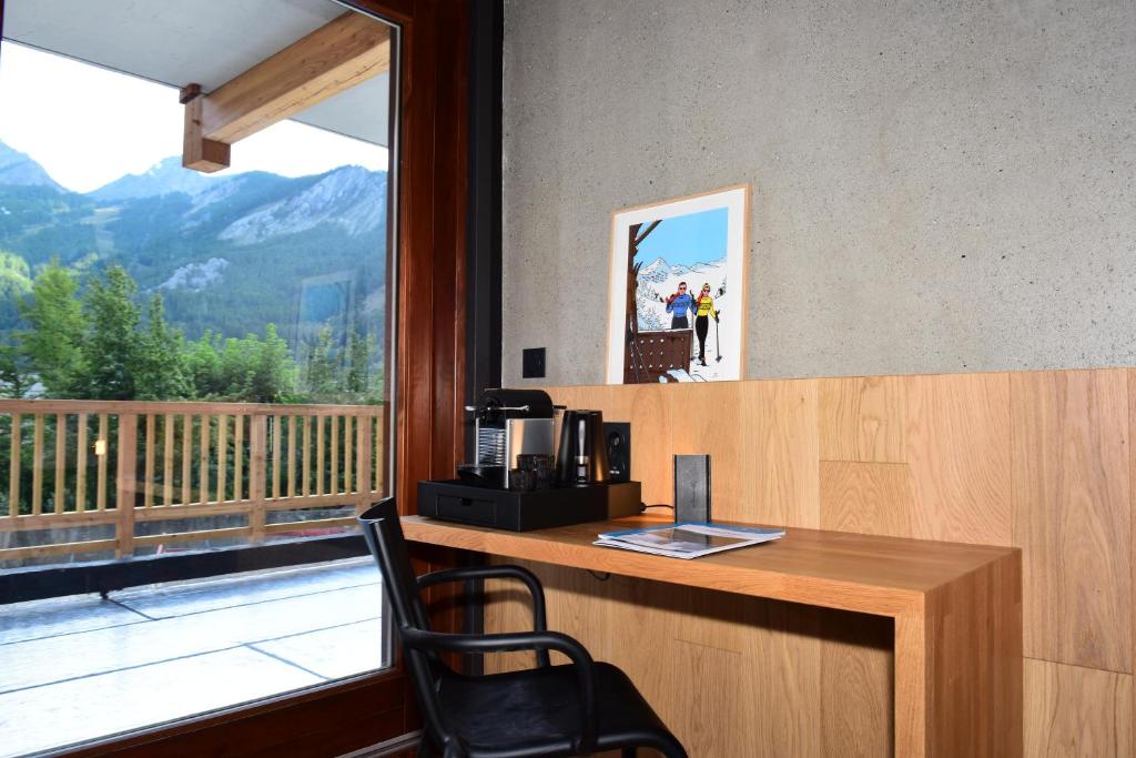 a office with a desk and a chair and a window at Hôtel Restaurant Le Monêtier in Le Monêtier-les-Bains