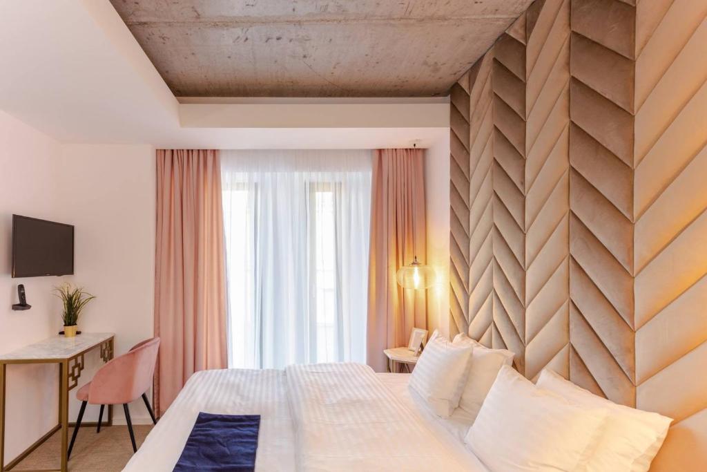a hotel room with a bed, chair, and nightstand at Filitti Boutique Hotel in Bucharest