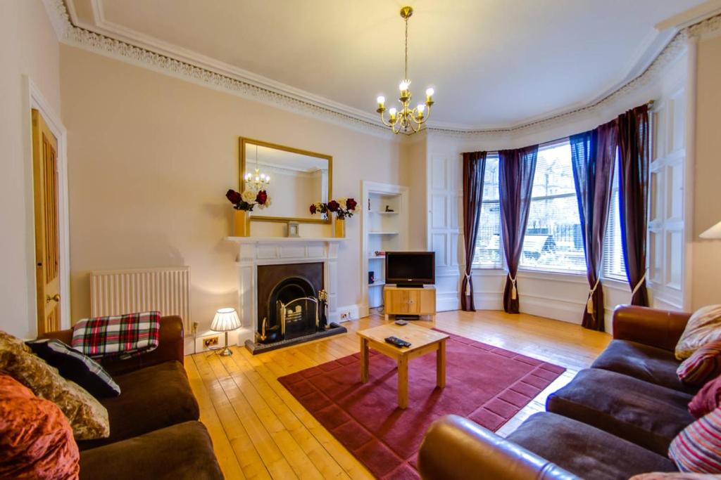 a living room with a couch and a fireplace at ALTIDO Modern 3 bed flat, closeby the Meadows & Old Town in Edinburgh