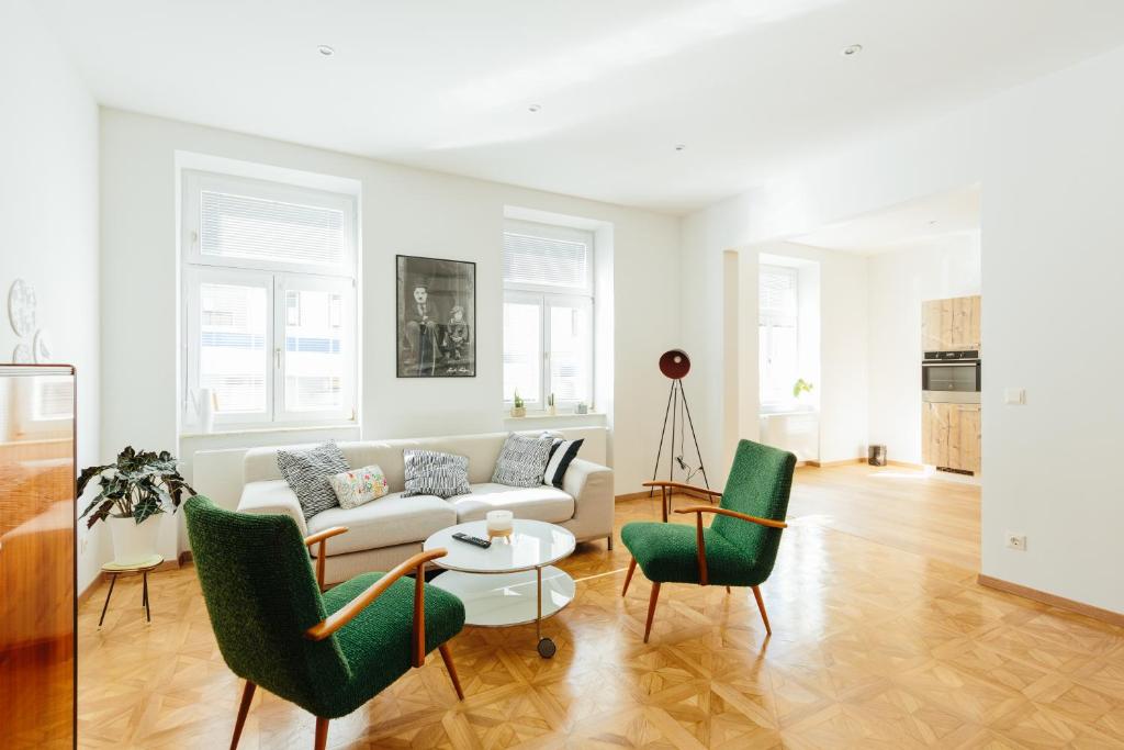 a living room with a couch and two chairs and a table at The newPAST Apartments in Vienna