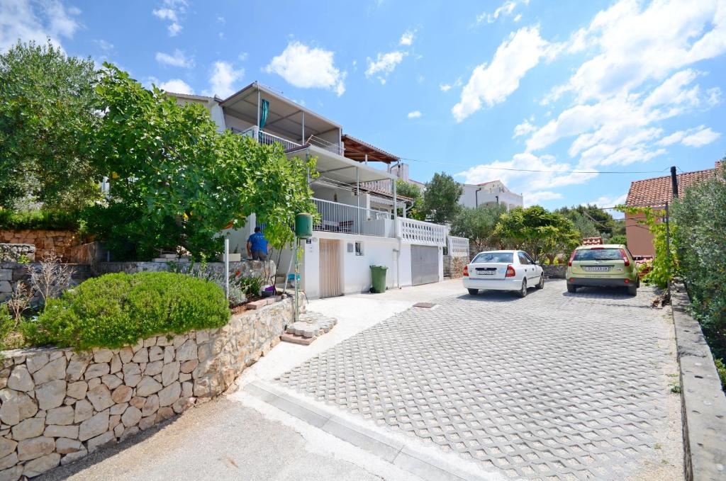 a street with cars parked in front of a house at Apartments Doris in Trogir