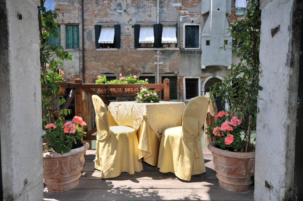 una mesa y sillas en un balcón con flores en Alla Vite Dorata, en Venecia
