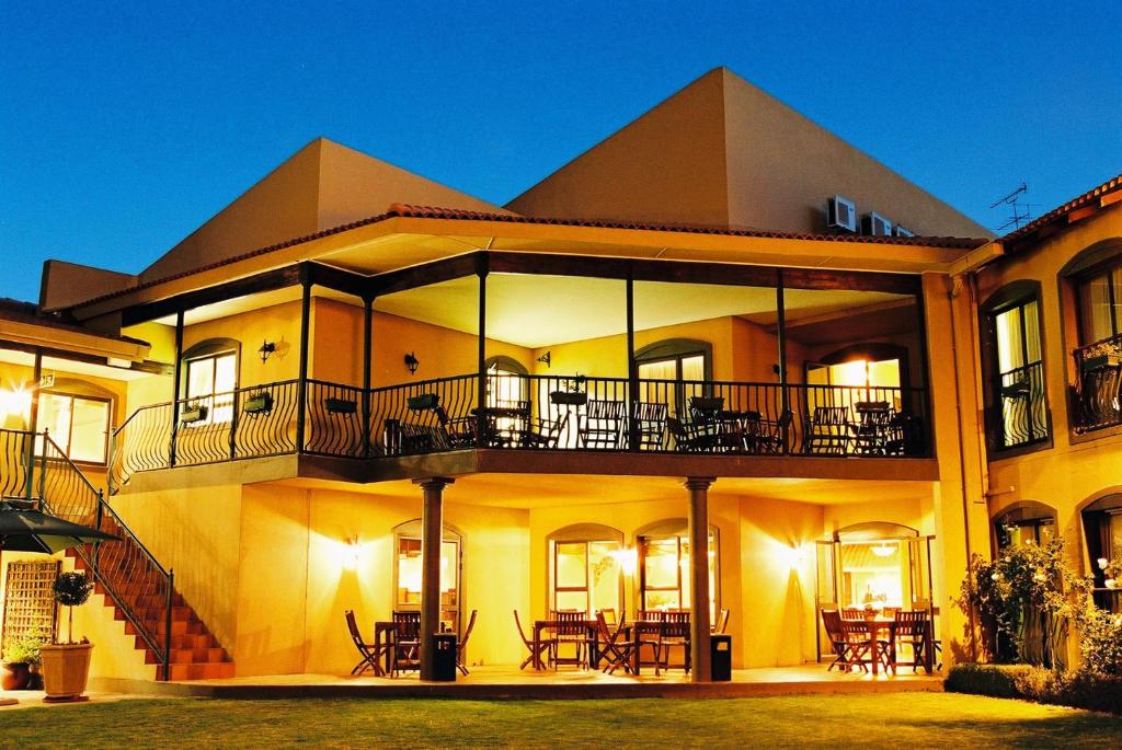 ein großes Gebäude mit Tischen und Stühlen davor in der Unterkunft Benvenuto Hotel & Conference Centre in Johannesburg
