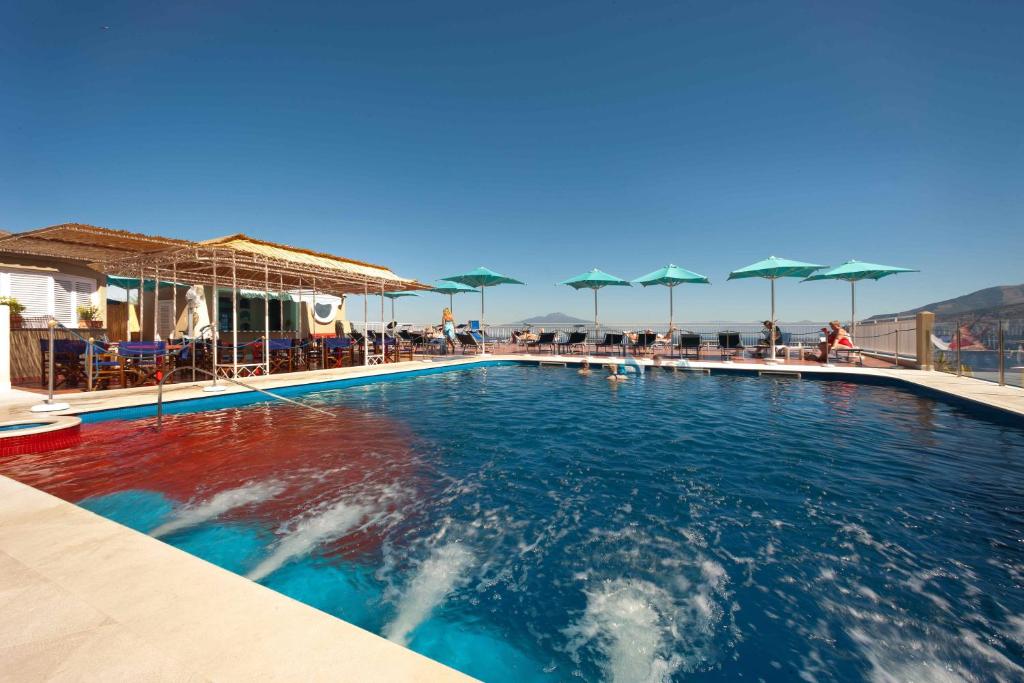 a swimming pool with umbrellas on a resort at Hotel Minerva in Sorrento
