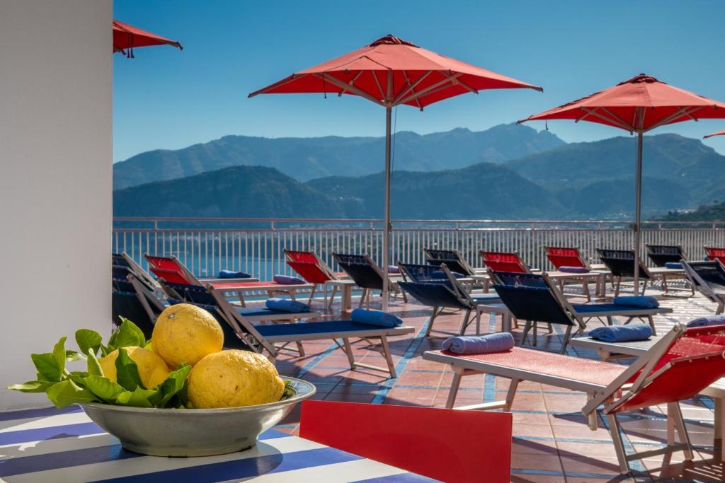 a group of chairs and tables and umbrellas on a roof at Hotel Minerva in Sorrento