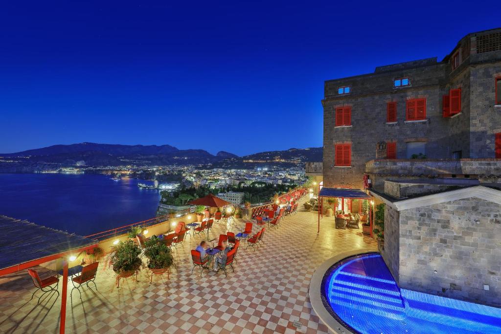 a hotel balcony with a view of the water at night at Hotel Minerva in Sorrento