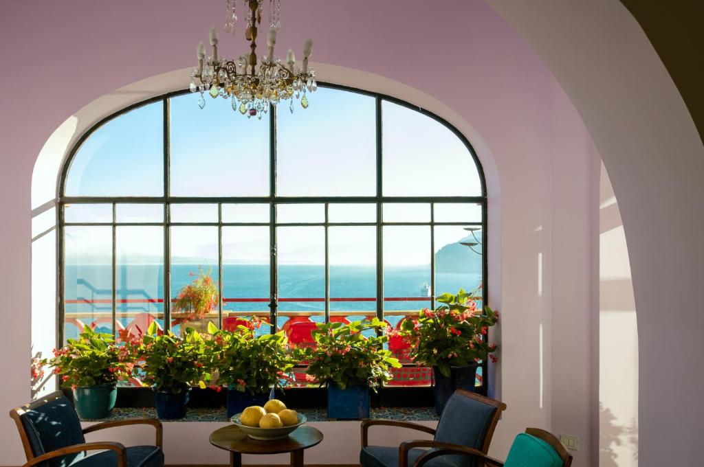 a dining room with a large window and a table and chairs at Hotel Minerva in Sorrento