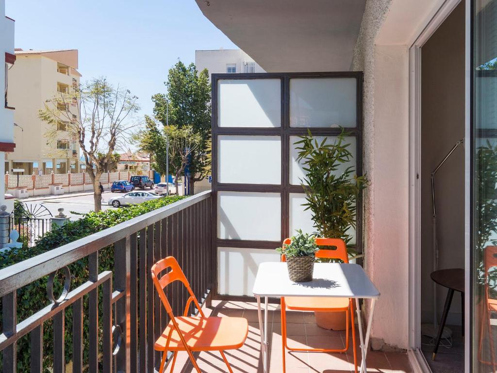 een balkon met een tafel en stoelen en uitzicht op een straat bij Apartment Estrella del mar by Interhome in Rincón de la Victoria