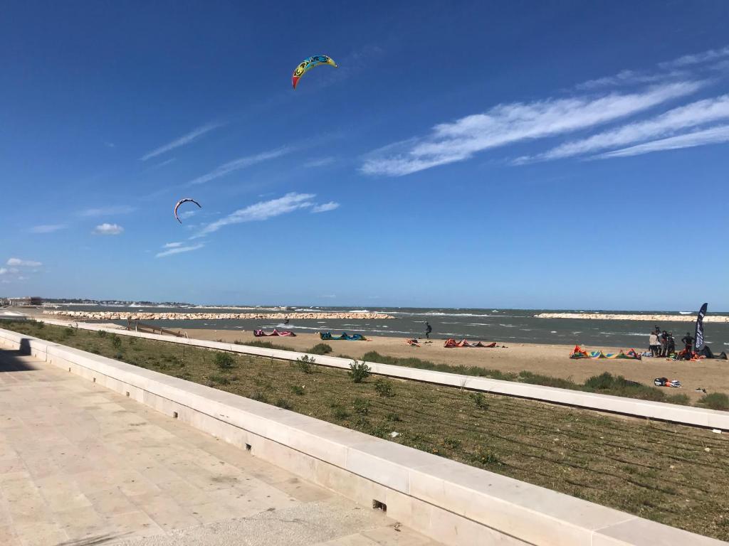 two kites flying in the sky over the beach at Bari Lory’s Home in Bari